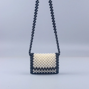 Detail of handmade beaded crossbody bag with black and white pearl weave texture