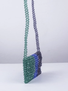 Détail du sac à bandoulière en perles acryliques avec des nuances vertes bleues violettes