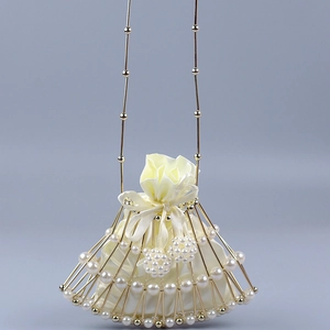Detail of fan-shaped evening bag featuring gold metal cage and pearl embellishments