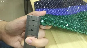 Gros plan des perles acryliques tissées à la main en vert, bleu et noir contrastant