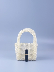 Detail of handmade pearl beaded mini handbag with lipstick for size comparison