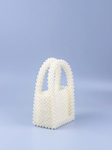Close-up of handmade woven pearl evening bag featuring intricate white acrylic beads