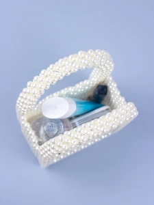 Detail view of woven pearl handbag interior showing storage capacity for cosmetics