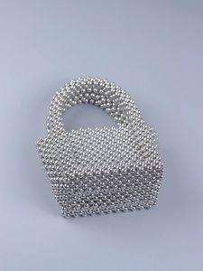 Detail of silver handcrafted pearl beaded clutch handbag with textured weave