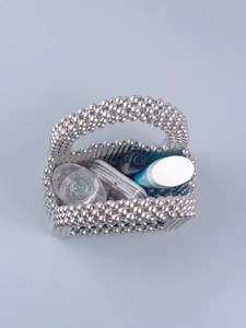 Top view of silver beaded handbag interior showing storage capacity for cosmetics
