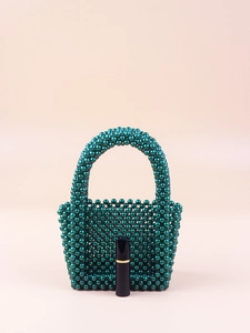 Detail of dark green beaded mini handbag with acrylic pearls and lipstick for scale