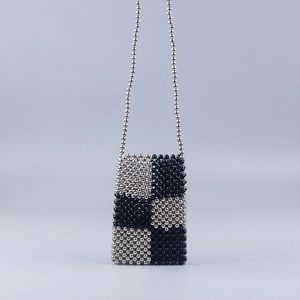 Detailed view of handmade woven beaded phone bag with black and silver checkered pattern