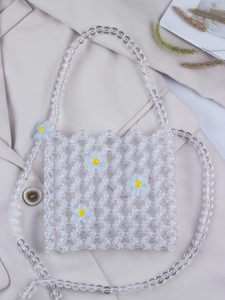 Detailed macro view of clear beaded shoulder bag with light blue 3D floral accents