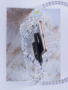 Top view of transparent beaded bag showing capacity for smartphone and lipsticks inside