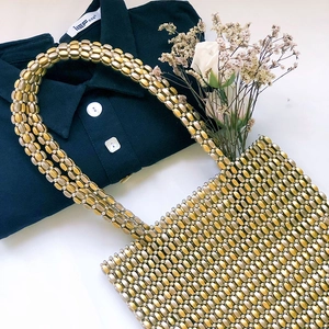 Vue détaillée du sac à main artisanal en perles métalliques dorées à doubles anses