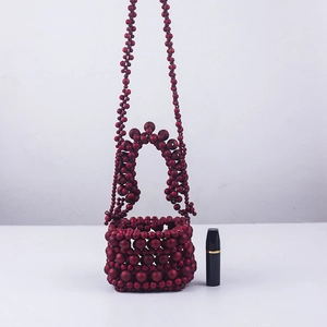 Detail of red beaded mini bucket bag with intricate handmade woven texture and top handle
