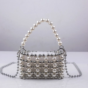 Macro shot of handmade mini pearl evening bag with metallic silver beads and woven texture