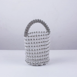 Détail de perles métalliques argentées et transparentes sur un sac seau fait à la main