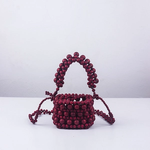Macro view of handmade deep red acrylic beaded evening bag with matte texture detail