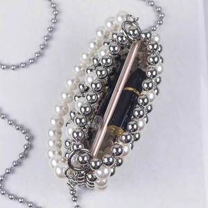 Handmade pearl beaded evening bag with silver chain, showing interior capacity with phone