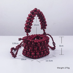 Macro shot of burgundy beaded bucket bag showing dimensions and crossbody strap detail