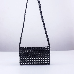 Detailed view of handmade black beaded crossbody bag with hollow square grid patterns