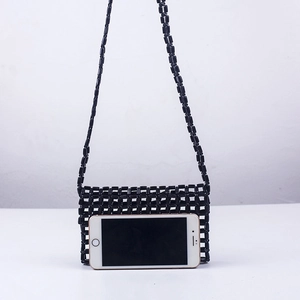 Detailed view of black beaded mini crossbody bag featuring hollow-out grid craft