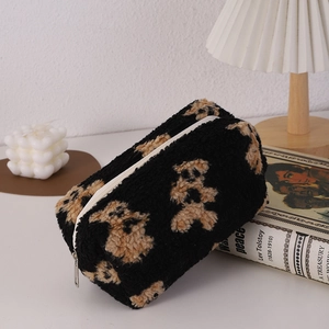 Detail of cute bear pattern on soft black plush makeup bag with zipper closure