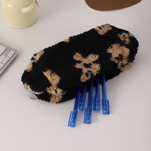 Close-up of black plush bear pouch with metal zipper showing blue pens inside