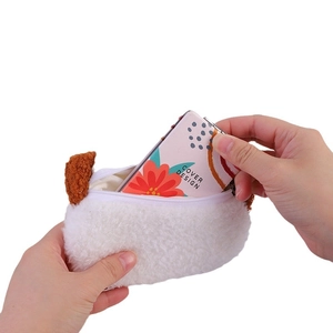 Plush white puppy coin purse with brown ears and zipper closure held by hands