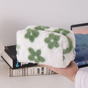 Close-up of soft white plush pencil case with green flower pattern and silver zipper
