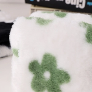 Close-up of soft white plush pencil case fabric with delicate green floral pattern