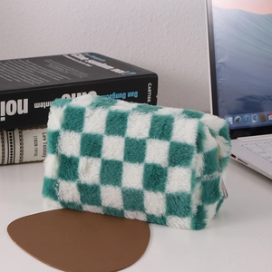 Macro shot of green checkered plush pencil case with zipper on a minimalist white desk