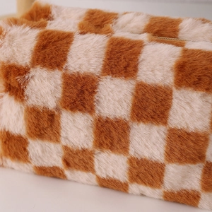 Detailed close-up of brown checkerboard plush fabric and zipper of the pencil case