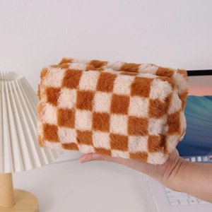 Close-up of fluffy checkerboard pencil case in brown and white plush material