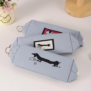 Detailed view of blue canvas pencil cases featuring dachshund prints and round metal ring zippers