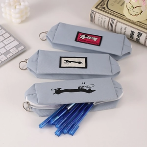 Close-up of light blue canvas dachshund pencil cases with zipper and stationery inside