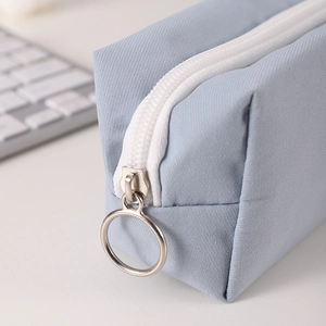 Detail of light blue pencil case with white nylon zipper and silver metal ring puller
