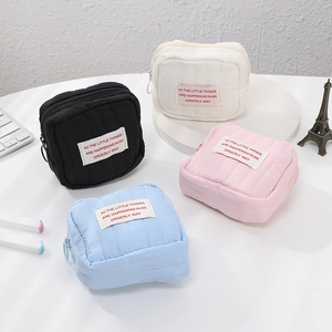 Quilted mini cosmetic pouches in black, white, pink, and blue with zipper closure