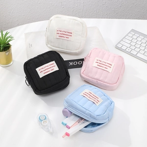 Flat lay of four colorful quilted cosmetic bags with zippers on a white desk