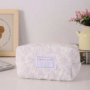 Detail of lavender quilted pencil case with floral butterfly texture and sweet girl tag