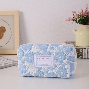 Detailed macro view of light blue floral quilted texture and sweet girl woven label