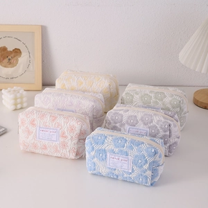 Detailed close-up of quilted floral pencil bags in multiple pastel colors and textures
