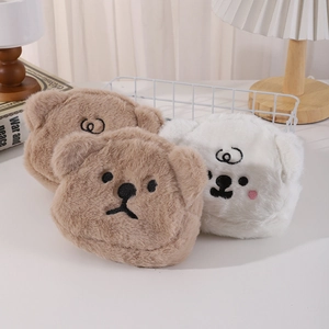 Close-up of soft plush bear storage bags with detailed embroidery in a cozy setting