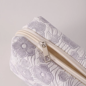 Close-up of vintage floral quilted fabric texture and silver zipper on a large pencil case