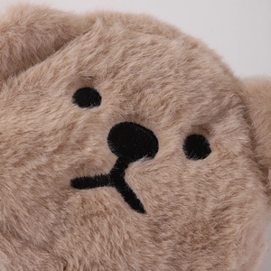 Close-up detail of soft plush bear pouch showing fluffy texture and cute embroidered face