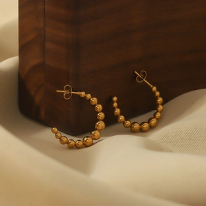 Classic 18k gold plated stainless steel C-shaped beaded hoop earrings on silk background