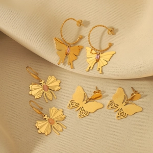 French retro gold butterfly earrings with zircon and amber stones on beige fabric