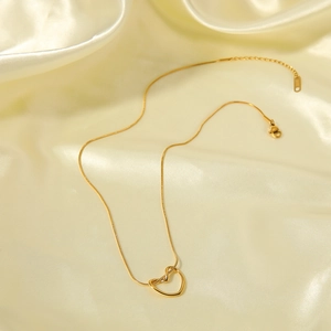 Élégant collier pendentif coeur évidé plaqué or avec chaîne serpent sur fond de soie