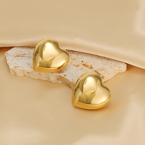 Detailed view of 3D heart-shaped gold stud earrings with a polished mirror finish surface