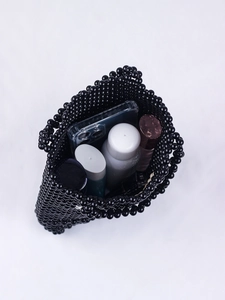Détail intérieur du sac en perles fait main montrant la capacité pour maquillage et mobile