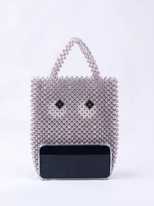 Détail du sac en perles fait main avec motif œil et smartphone pour référence de taille