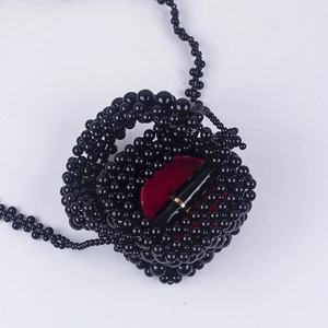 Handmade black beaded bucket bag with long shoulder strap and interior item storage view