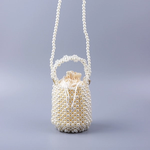 Détail du sac seau en perles avec doublure en satin champagne et texture tissée main