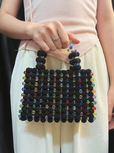 Detail of a handmade black beaded handbag with vibrant colorful candy beads and ring handles
